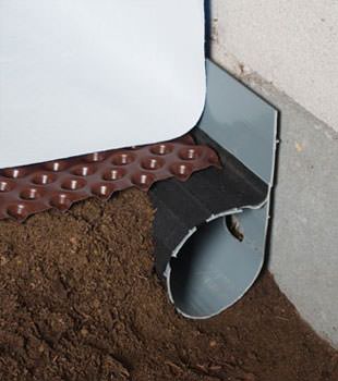 Closeup of a crawl space drainage system installed in Forest