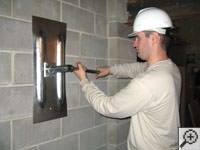 Attempting to straighten a bowed foundation wall by straightening a wall anchor system in a Clinton home.