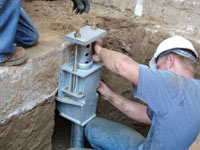 Foundation repair contractors installing the foundation bracket in New Orleans.