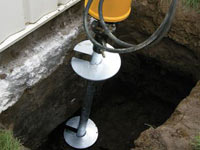 Installing a helical pier system in the earth around a foundation in Baton Rouge